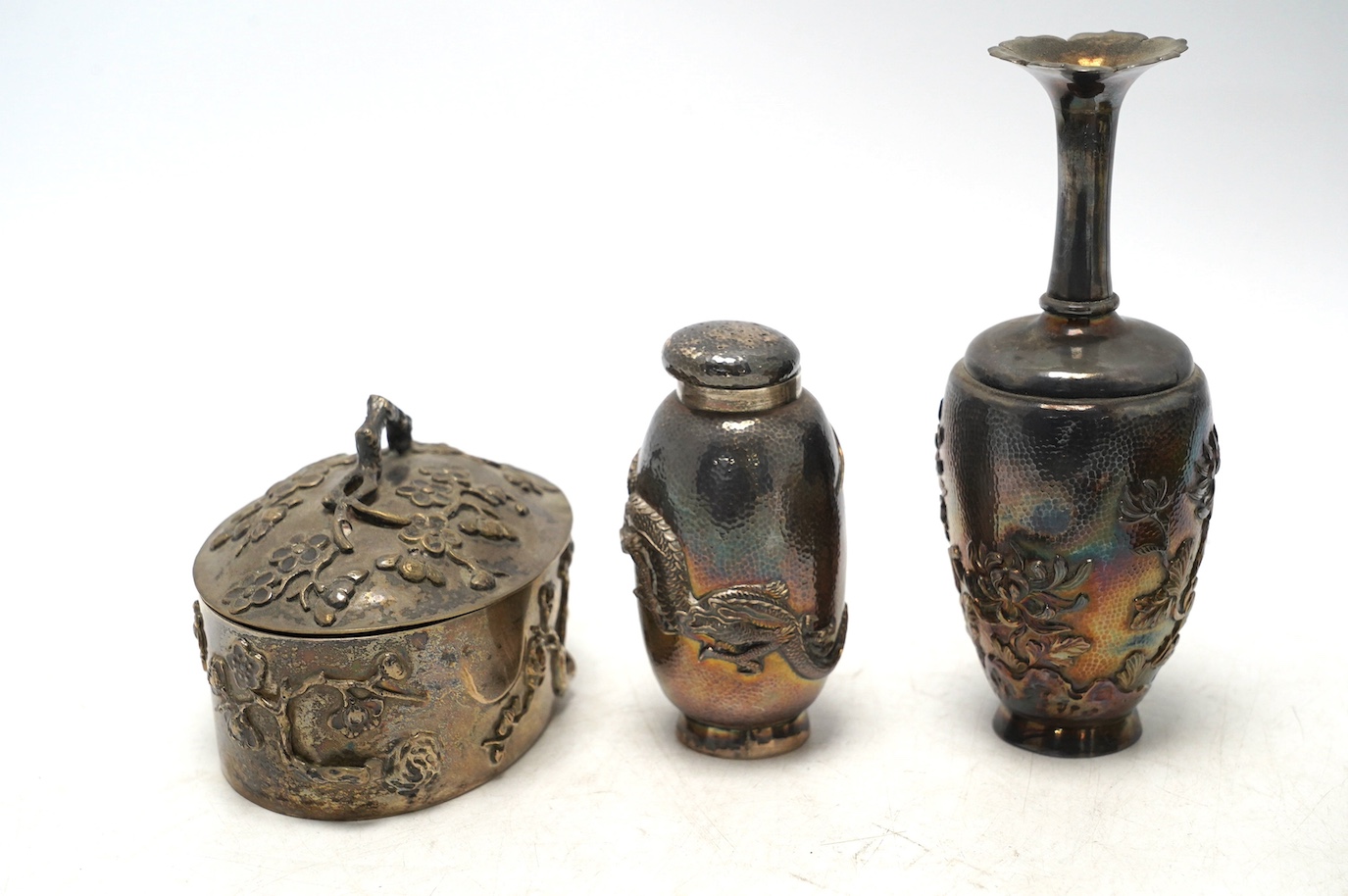 An early 20th century Japanese oval white metal box and associated? cover, 10.2cm, together with a similar posy vase, jar without cover and three mounted clothes brushes. Condition - fair to poor